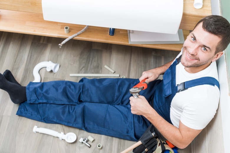 What should I do while waiting for the emergency plumber to arrive?